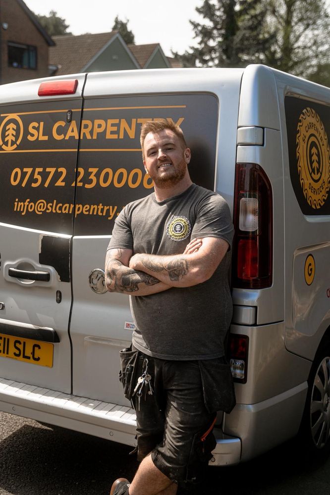Sean Doyle, founder of SL Carpentry & Construction, standing in front of the branded company van in Crawley