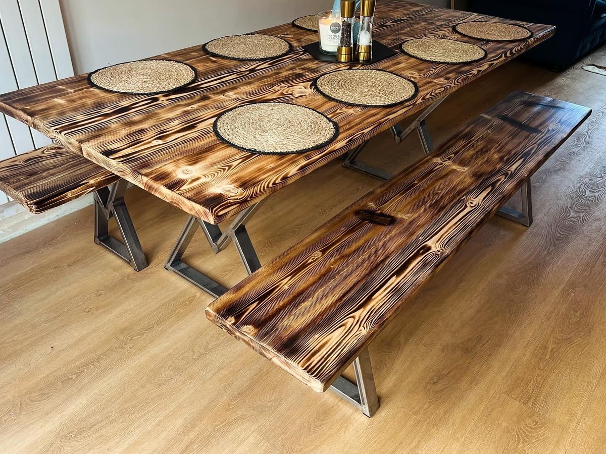 Bespoke 8ft by 4ft scorched-timber dining table with matching benches, mahogany bowtie inlays and steel X-frame legs